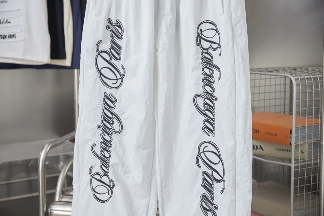 Balenciaga 𝘽𝘼𝙇𝙀𝙉𝘾𝙄𝘼𝙂𝘼 BLCG 26SS 71 cursive signature letter embroidery sports suit Light luxury A must-have item for men and women's daily commuting Correct version Welcome to compare Detailed features · Customized matt Taslan jacket fabric · The fabric has undergone a waterproof coating process · The interior is made of three-grade polyester bird's eye mesh · OS ultra-loose silhouette design · Side zipper pockets Small stand-up collar design · Internal zipper pocket design · Elastic waistband design at the hem · Customized molded hardware zipper Jacket double puller design · Tajima high-speed embroidery machine with 100,000-needle three-dimensional design · Double side pockets on trousers · Original main mark and washed tag brand packaging Color: Black/White Size: 46/48/50/52